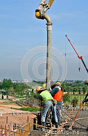 Construction Workers Using Concrete Hose from Concrete Pump Stock Photo